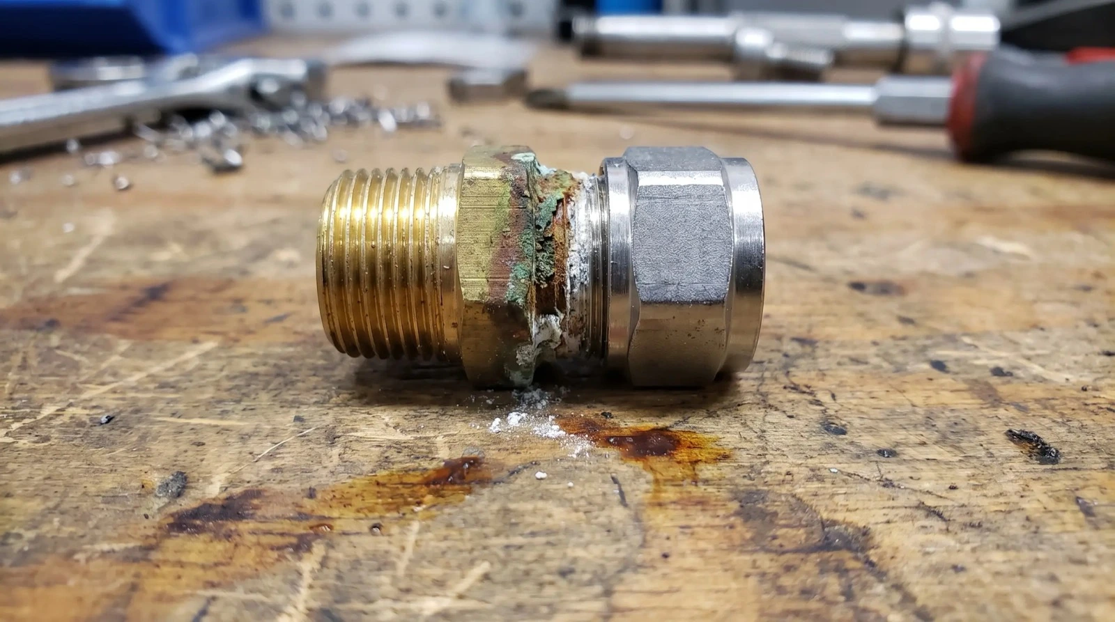 Brass fitting joined to stainless steel showing corrosion staining at the galvanic junction